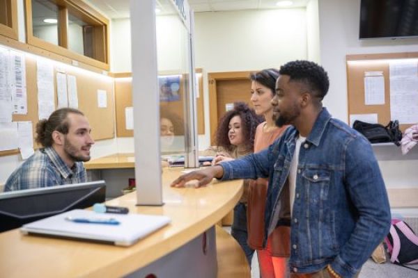 People talking while standing at a front desk