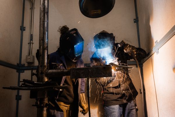 two welders work together