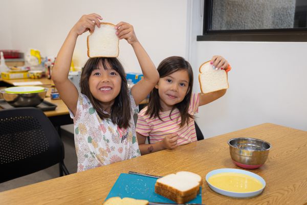 two girls holding up bread