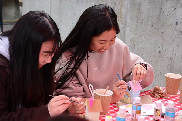 Students painting colourful birdhouses
