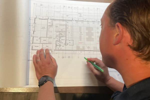 Phil D'aoust looking over a blueprint
