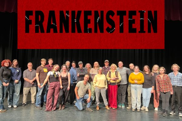 the cast of approximately 20 people standing on a stage