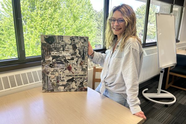 Mariah Matthews standing with her art work