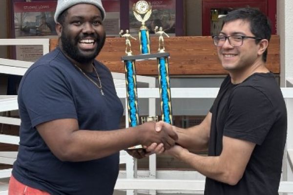 two students holding a trophy 