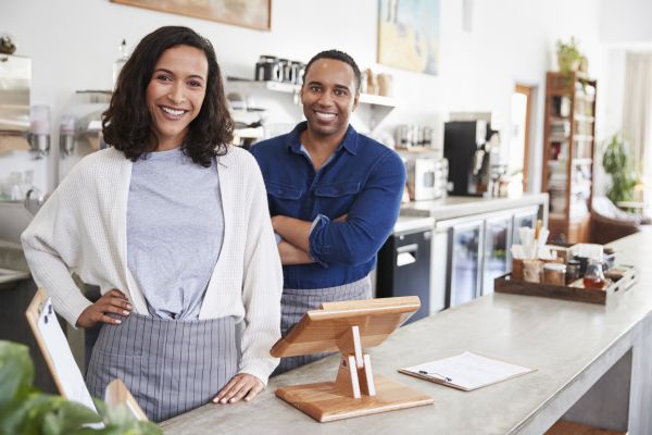 Mixed race male and female behind a counter at their coffee shop
