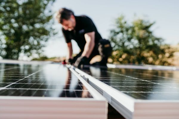 A person installing solar panels on the roof