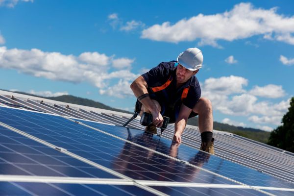 A professional installing solar panels on the roof