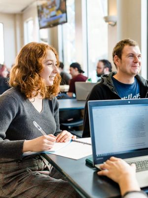 Three students studying as a group in the cafeteria on the Kelowna campus