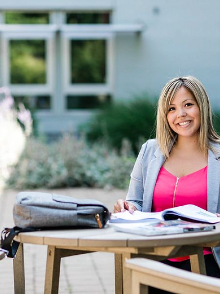 Sophie Wilson sits at a picnic table at the Penticton campus