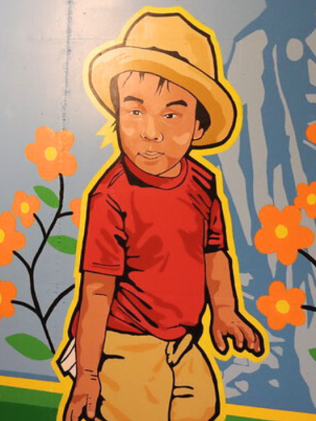 Close up of young boy in mural in red shirt and hat