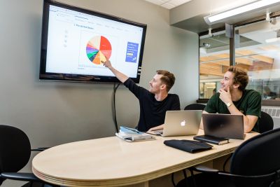 Two students collaborating on a project in a library study room