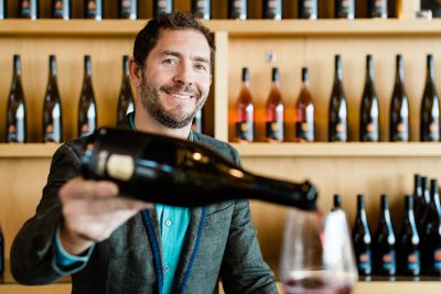 A man pouring wine in a tasting room.
