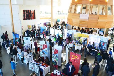 employers standing at their booths as students approach to discuss opportunities 