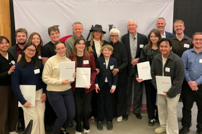 group photo of 17 people, mix of ages and genders, including the Hall family, OC President Neil Fassina, and students