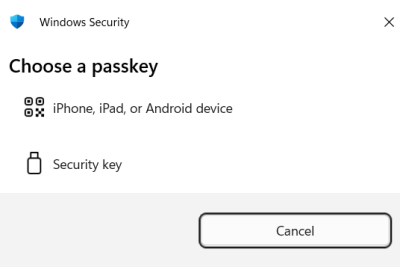 A Windows Security window that displays the option to "choose a passkey." Options include either using an "iPhone, iPad, or Android device" or a "security key."