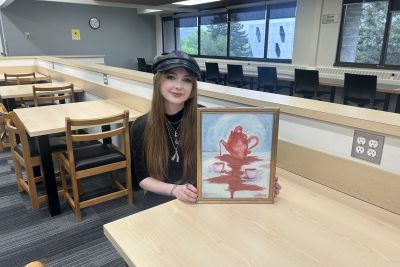 Julia Harley holding her painting titled "Pour your heart out"