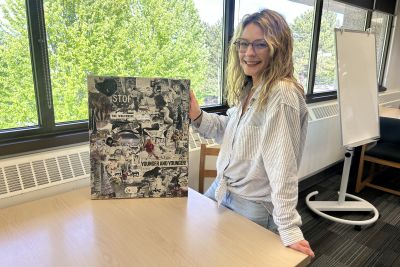 Mariah Matthews standing with her art work