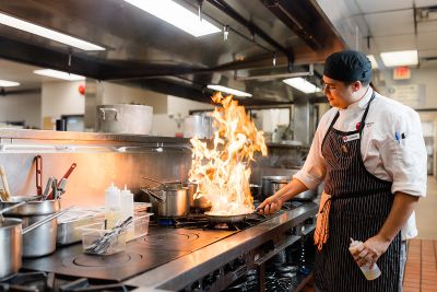An OC culinary student works in one of OC’s learning kitchens.
