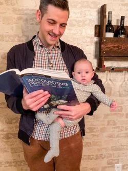Business Administration Professor Josh Widman reads to his daughter
