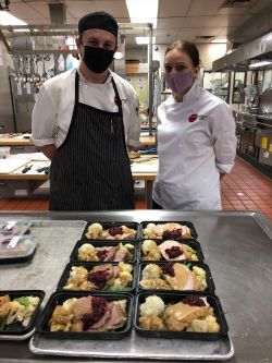 OC Culinary Arts students stand in front of a few Thanksgiving meals