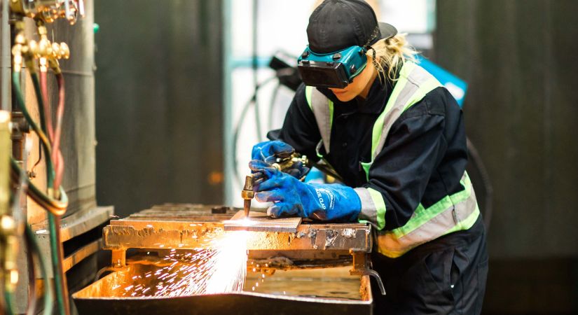 Welding student works on a project with sparks flying