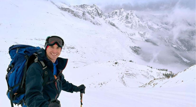 A man stands in the snowy mountains
