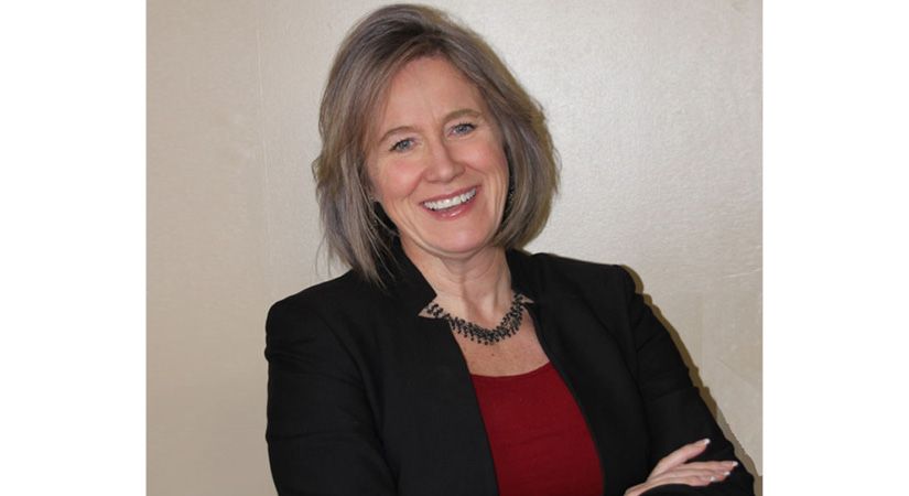 A smiling woman with short hair is pictured.