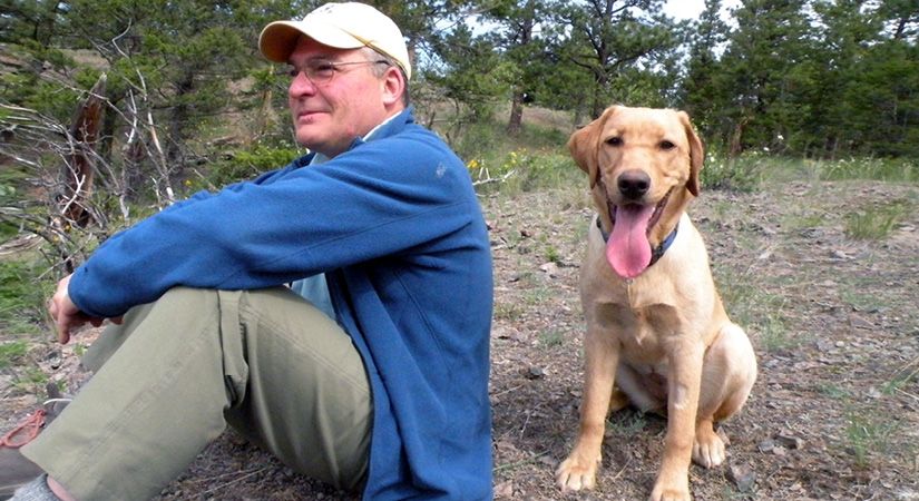 Norm Corbett sits outside with his dog, Daisy.
