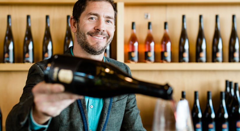 A man pouring wine in a tasting room.