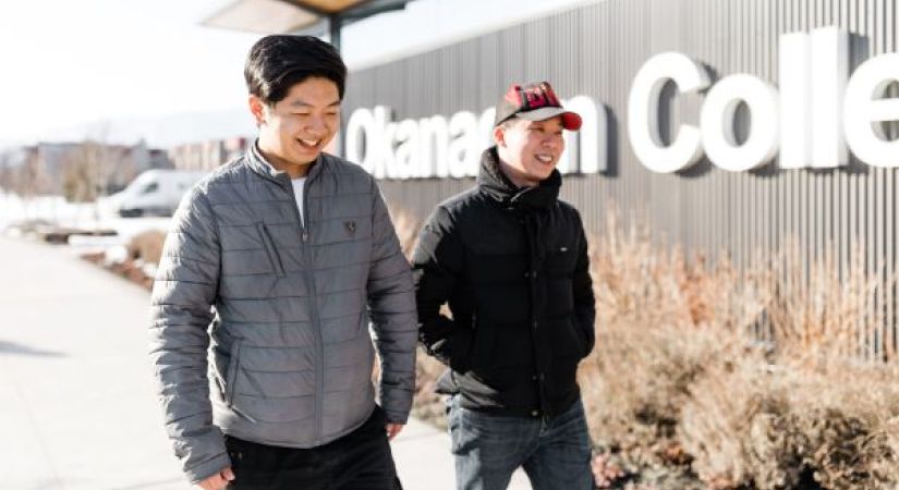 two students walking in front of the Okanagan College Trades building