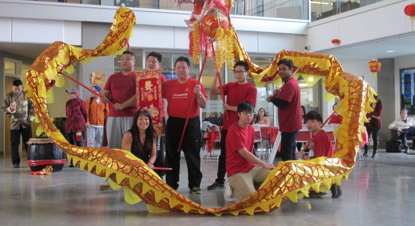 OC staff members pose with Dragon dancers at Lunar New Year celebration