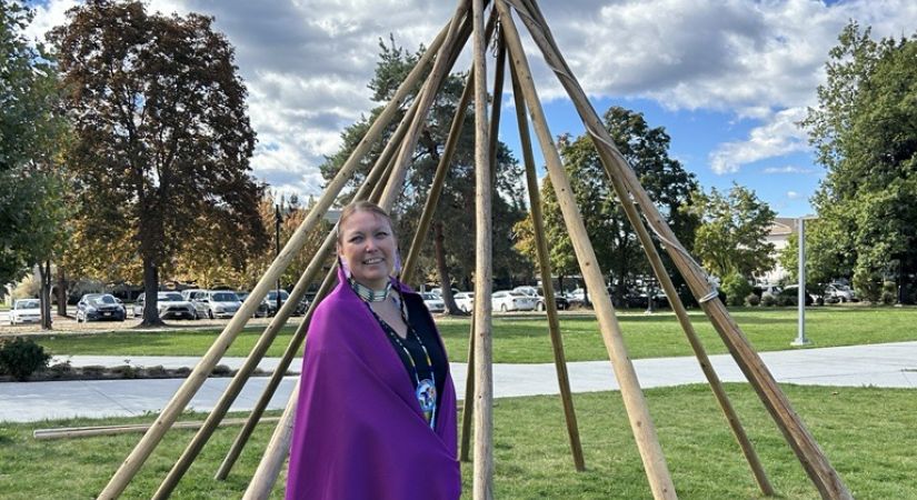 Rhea Dupuis in front of a tipi