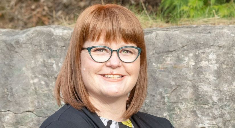 Dr. Agnes Weighil smiles infront of a rock wall