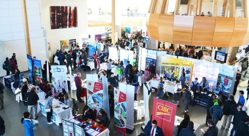 employers standing at their booths as students approach to discuss opportunities 