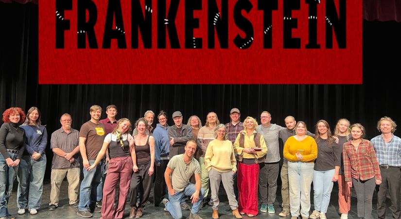 the cast of approximately 20 people standing on a stage