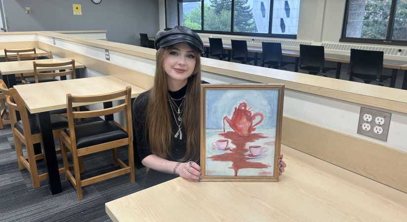 Julia Harley holding her painting titled "Pour your heart out"